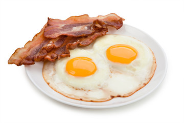 Plate with fried eggs, bacon isolated on white background