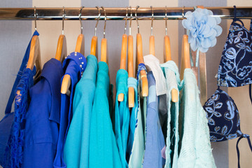 Dressing closet with blue clothes arranged on hangers