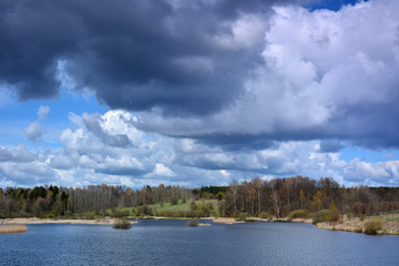 Wild spring landscape with lake and clouds