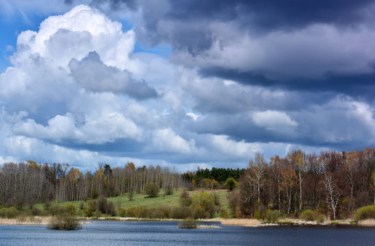 Wild spring landscape with lake and clouds