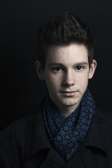 Fototapeta premium Young man in coat and scarf, portrait