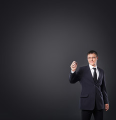 Successful and smart businessman writing imaginary text over gre