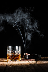 Glass of alcohol and smoking noble cigar on a black background © Jarek Pawlak