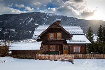 traditional wooden house in Alps covered with snow