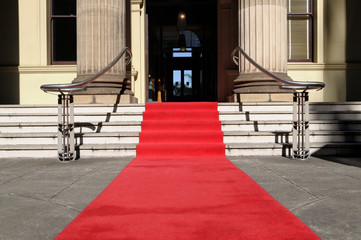 Red carpet at the entrance to a luxury hotel cinema or movie theater awards ceremony with steps...