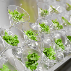 Many glasses with salad leaves