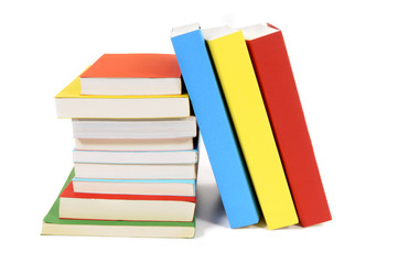 Collection of colorful paperback books in a row line with small stack isolated white background photo