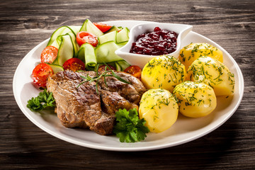 Fried steak, boiled potatoes and vegetable salad