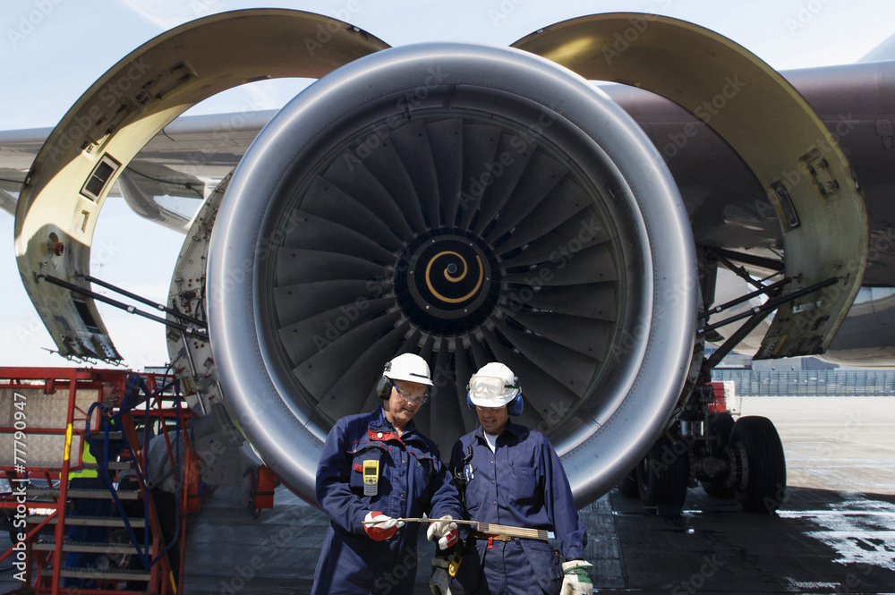 Wall mural airplane mechanics in front of jumbo jet engine