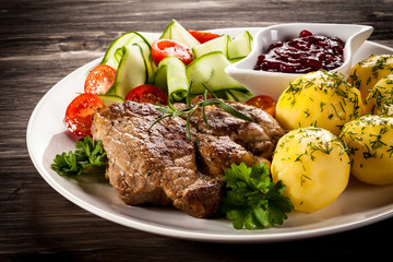 Fried steak, boiled potatoes and vegetable salad