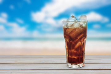 glass of cola with ice on wood