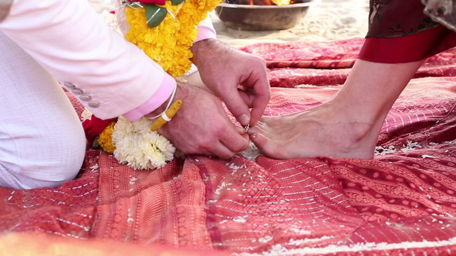 bride stretched her leg on rice road on traditional indian