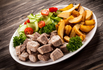 Grilled meat with baked potatoes and vegetables
