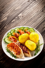 Fried chicken fillets, boiled potatoes and vegetable salad