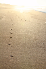 footprints in the sand at sunset