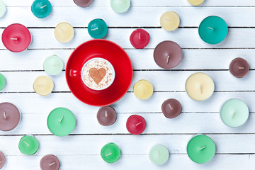 Cappuccino and candles on white background