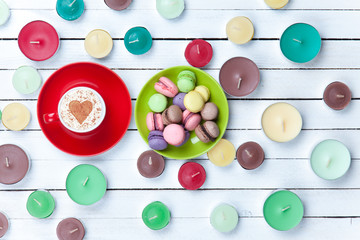 Cup of Cappuccino and candles with macarons