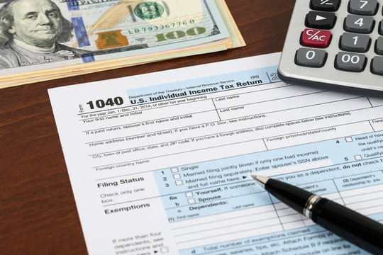 Tax form with pen, banknote, and calculator taxation concept