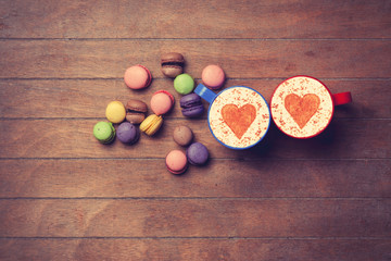 Cup and macarons on wooden background