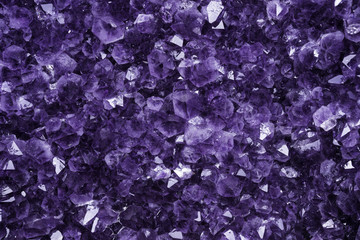 Dettaglio dei cristalli viola di un ametista gigante con qualche riflesso e luce piatta.