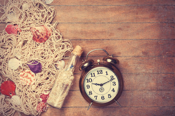 Retro alarm clock and net with shells and bottle