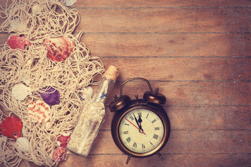 Retro alarm clock and net with shells and bottle