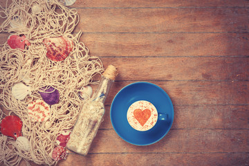 Cup and net with shells and bottle