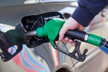 man filling up car with fuel at petrol station