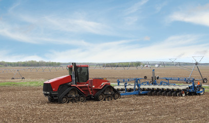 Fototapeta premium Red Farm Tractor and Planter