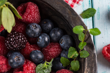 Fresh summer berries fruits in vintage bowl on rustic table