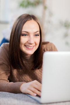 smiling woman chatting with compiuter
