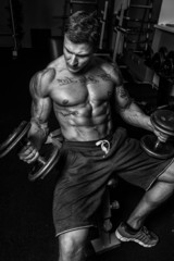 Obraz na płótnie Canvas Sportsman is doing exercises in gym