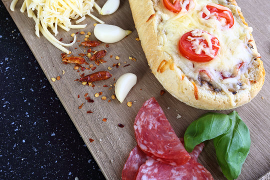 Home casserole on a baguette with cheese salami and tomato