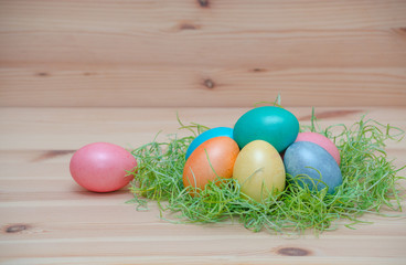 happy easter eggs pastel colored in a nest with candle on the