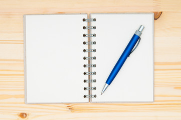 Notebook and pen on wooden surface