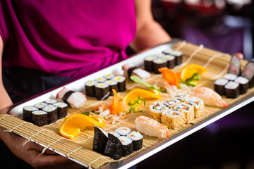 Obraz na płótnie Canvas Kellnerin mit Sushi in Asia Restaurant