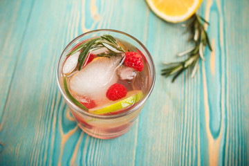 detox water with ice and fruits in glass, toned