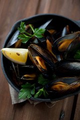 Steamed mussels with parsley and lemon, selective focus