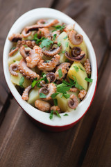 Octopus salad in a glass bowl, selective focus, vertical shot