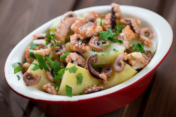 Glass bowl with italian octopus salad, close-up, selective focus