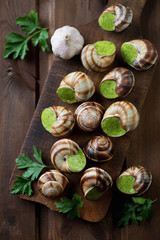 Rustic wooden chopping board with escargots de Bourgogne