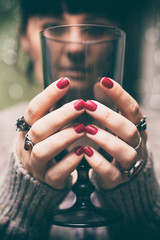 Girl with red painted nails holding a glass