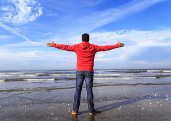 Man with his hands up on the beach