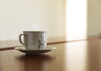 Cup and a stack of papers on his desk
