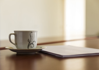 Cup and a stack of papers on his desk