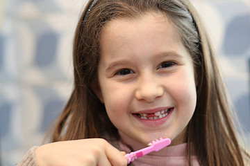 pretty little girl while washes the teeth with a brush