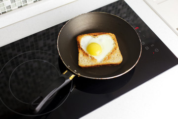 Slice of cereal toast bread with cut out heart shape full egg on