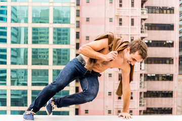 Man jumping a Corbel of a Rooftop © harodominguez