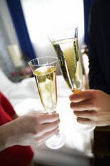 Hände eines jungen Brautpaars an Sektgläsern