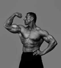 Portrait of muscle man posing on grey background